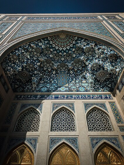 A detailed architectural facade with intricate tile work and arched windows. 4