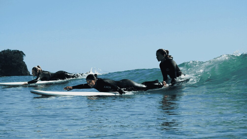 Three surfers riding waves in the ocean. 2