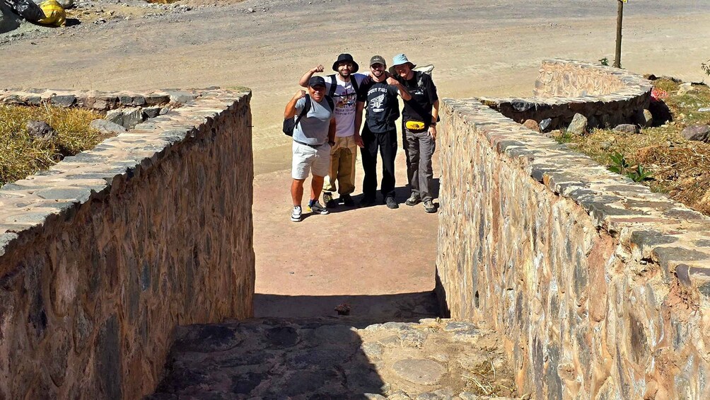 A group of people standing in a stone-lined pathway. 2