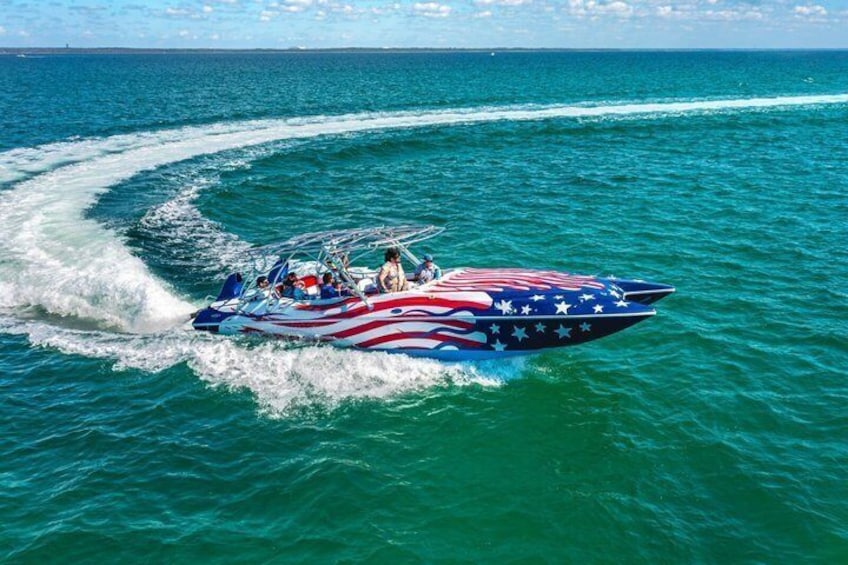 A speedboat with an American flag design on the side, moving through the water. 1
