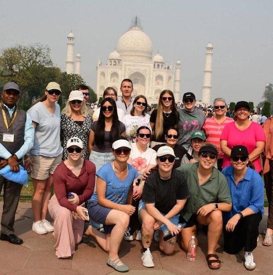 A group of people posing in front of the Taj Mahal. 5