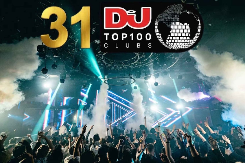 A crowded nightclub with a DJ booth, stage lights, and smoke effects. 1