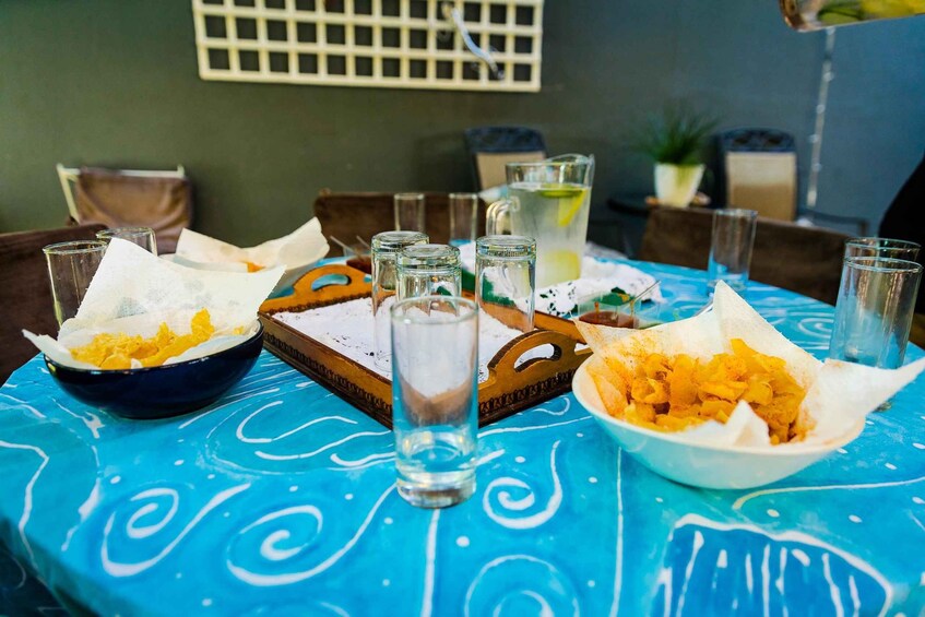 A table with bowls of food, glasses, and a pitcher of drink. 2