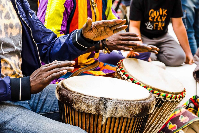 A person playing a drum with a fur edge. 5