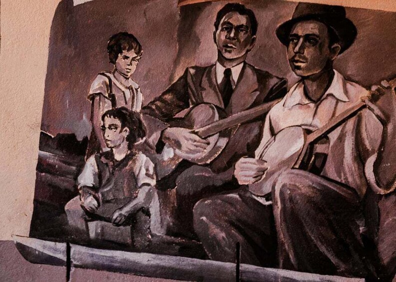 A mural with three figures, one adult and two children, seated and standing. 4