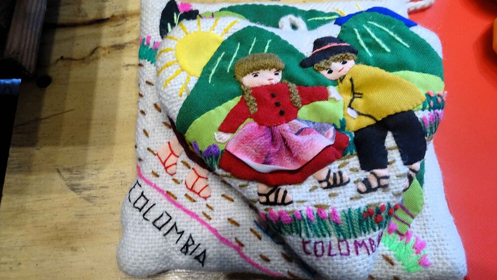 A knitted item with embroidered figures and the word "COLOMBIA". 5
