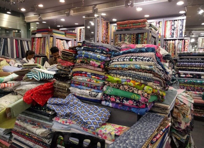 A fabric store with stacks of colorful textiles and patterns. 3