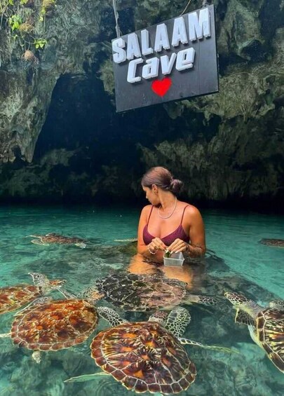 A person feeding sea turtles at Salaam Cave. 2