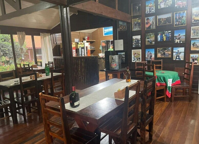 A restaurant with wooden furniture, a green tablecloth, and a wall decorated with photographs. 2
