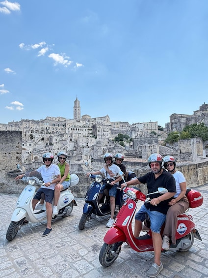 A group of people on scooters with a historic cityscape in the background. 2