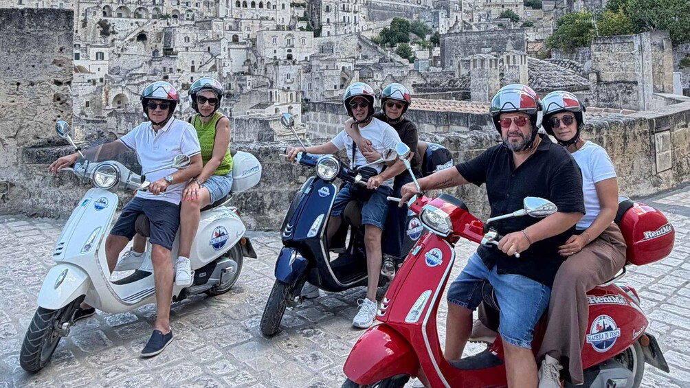 A group of people on scooters in a historic town with stone buildings. 2
