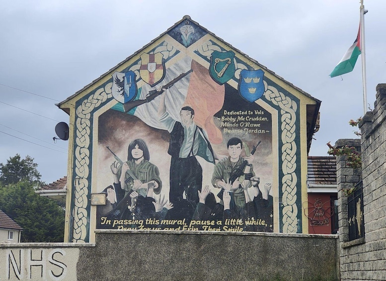 A mural with soldiers, flags, and a message dedicated to Vols Bobby McCradden, Mungo O'Rawe, Pearse Jordan. 2