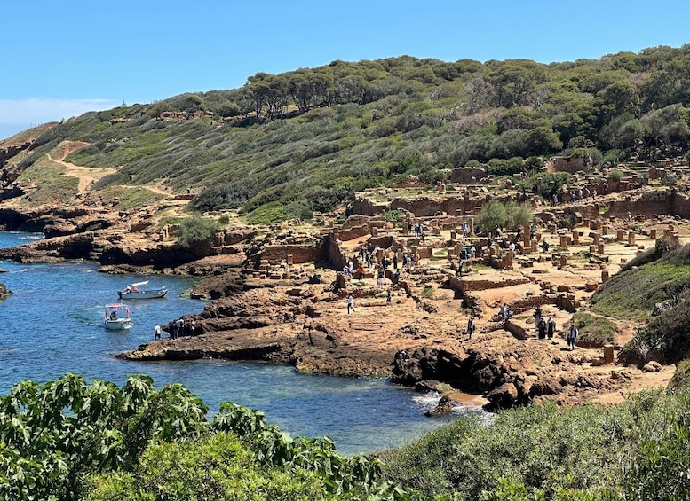 A coastal archaeological site with ruins and visitors. 2