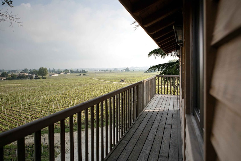 A wooden balcony overlooking a vineyard. 2