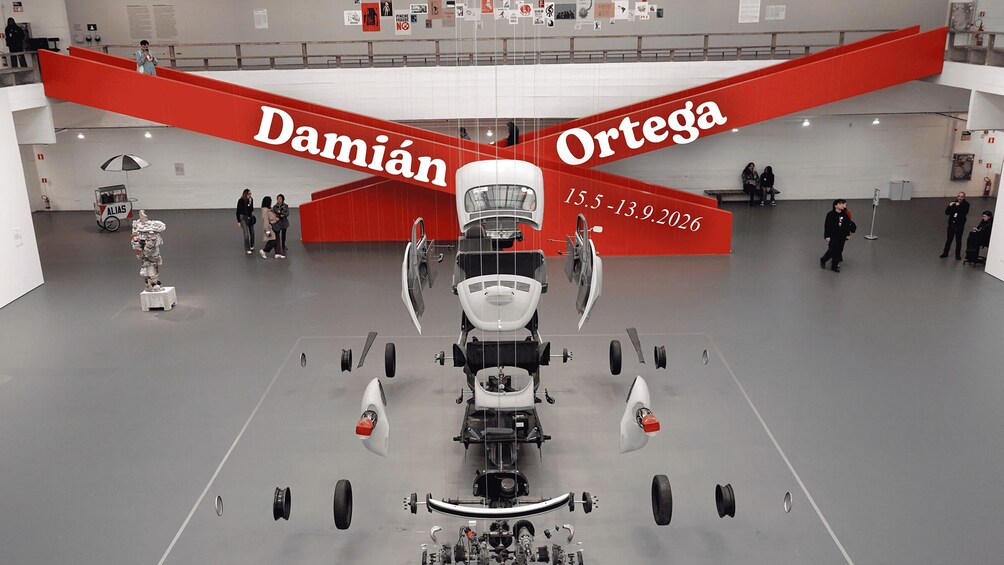 A car exhibit with a red wing labeled 'Damian Ortega' and a date '15.5 - 13.9.2026'. 1