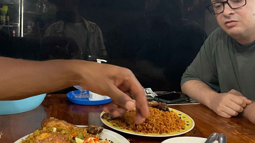 A person eating rice with meat and vegetables. 5