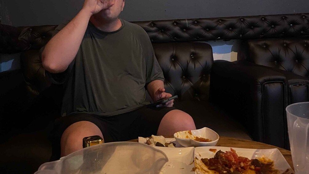 A person sitting on a leather couch, holding a smartphone. 3