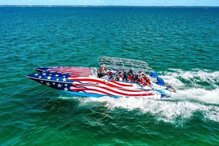 Un motoscafo con decorazione a tema bandiera americana, passeggeri e acqua. 2