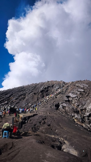 A rocky mountain with a crowd ascending a steep path. 4