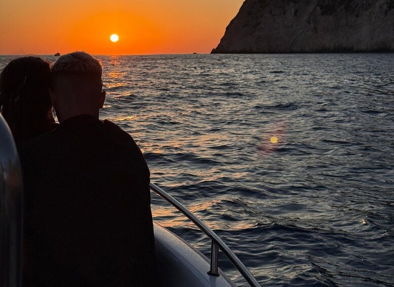 A sunset over the ocean with a rocky cliff in the background. 5