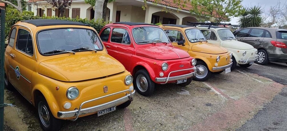 A row of vintage cars parked in a lot. 5