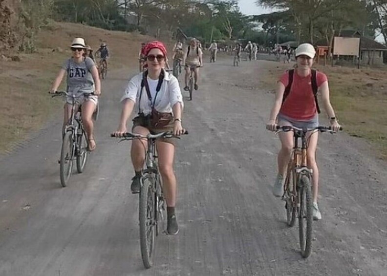 People riding bicycles on a dirt road. 4