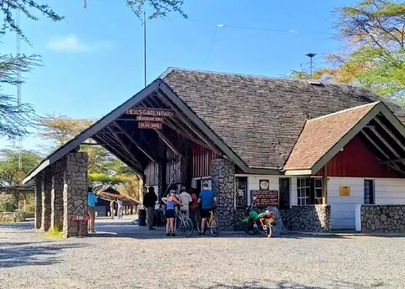 A covered area with a sign reading 'Hell's Gate Park' and a stone building with a red roof. 2