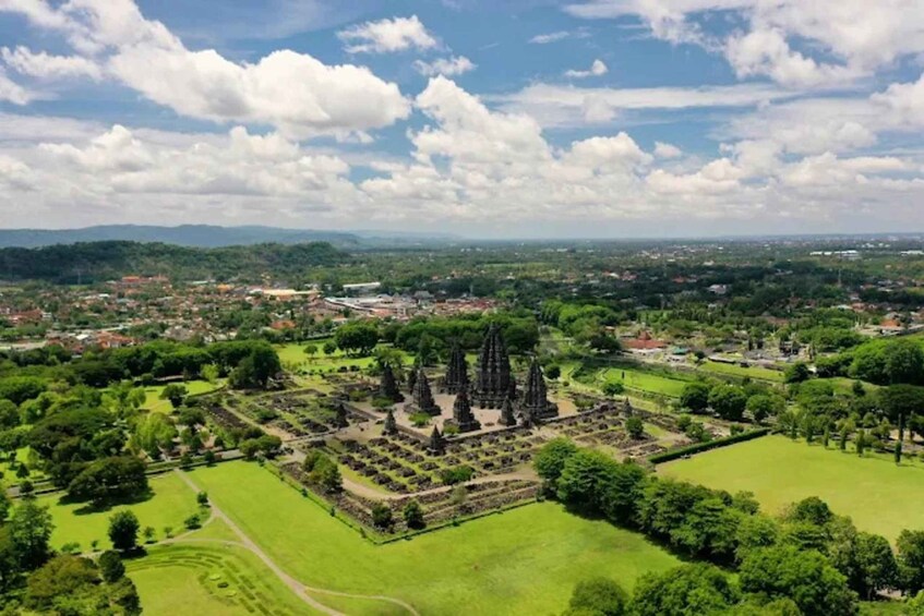 A lush green landscape with a historical site featuring tall, narrow towers. 4