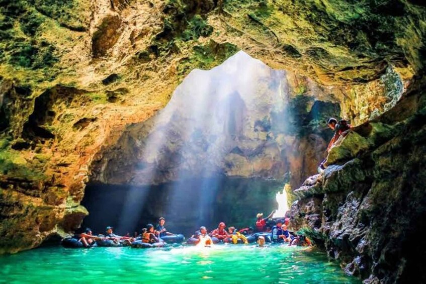 People rafting in a cave with water. 3