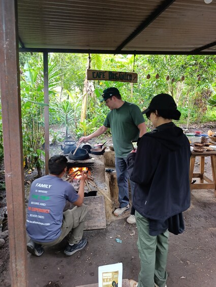 A rustic outdoor cooking area with a sign reading 'Cafe Organico.' 2
