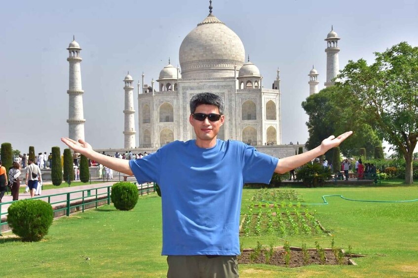 A person standing in front of the Taj Mahal with arms outstretched. 3
