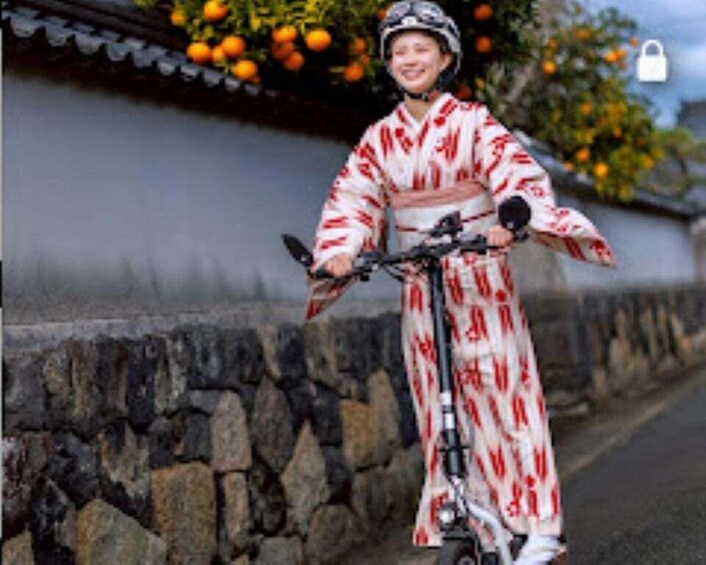 A person in traditional attire riding a bicycle on a street with stone walls and orange trees. 2