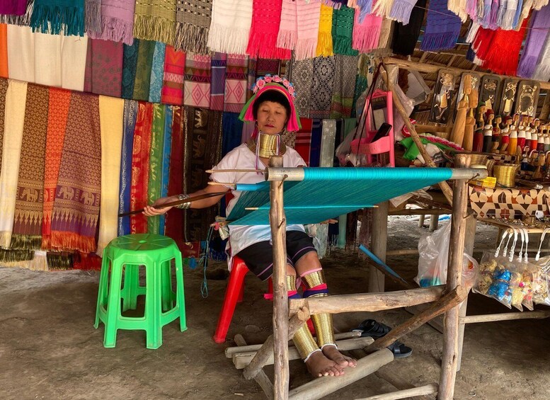 A person weaving colorful textiles at a loom. 5