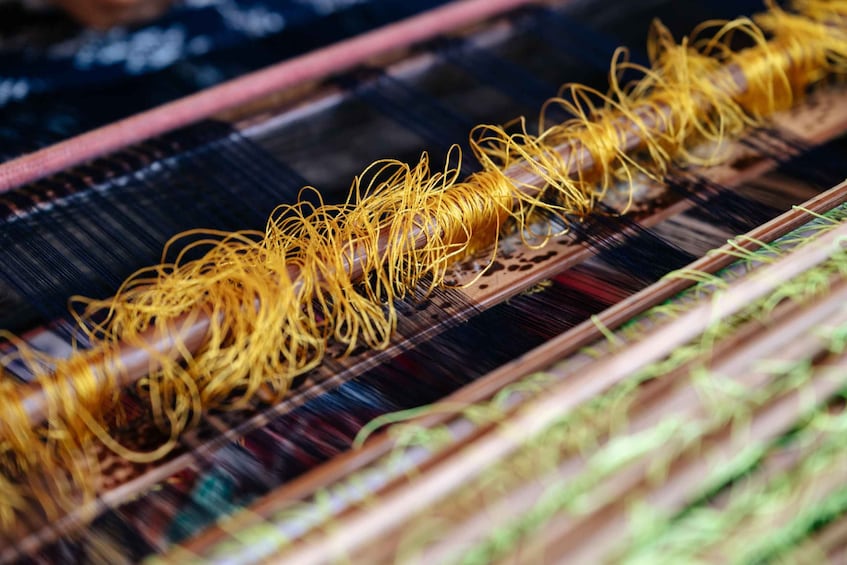 A close-up of a loom with yellow threads. 4
