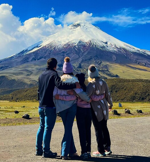 A family standing on a road, facing a snow-capped mountain. 3