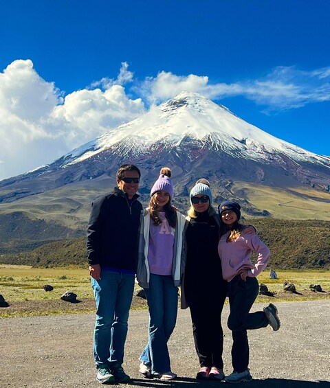 A group of people standing in front of a snow-capped mountain. 4