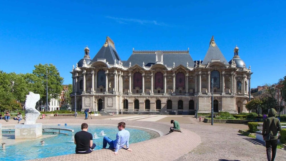 A historic building with a fountain in the foreground. 3