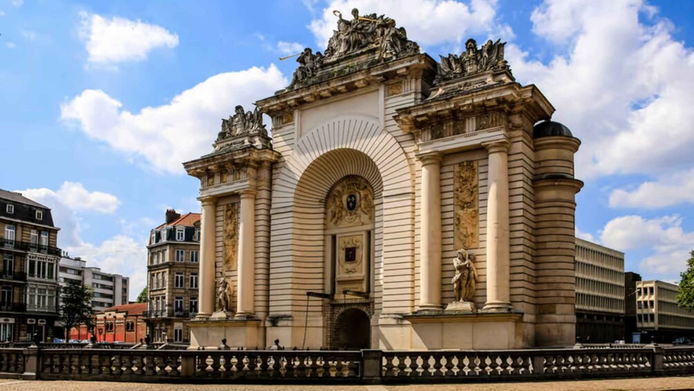 A grand historical building with ornate sculptures and a large arched entrance. 2