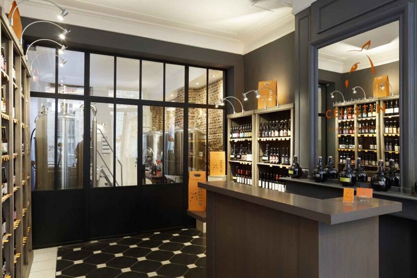 A bar with a black and white checkered floor, shelves of bottles, and a large window. 2