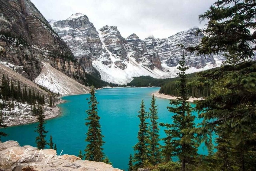 A mountain lake surrounded by snow-capped peaks and dense forest. 2