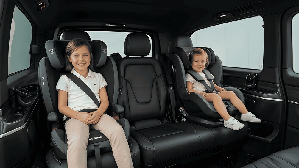 Two adults and a child seated in a car's back seat, both wearing seat belts. 4