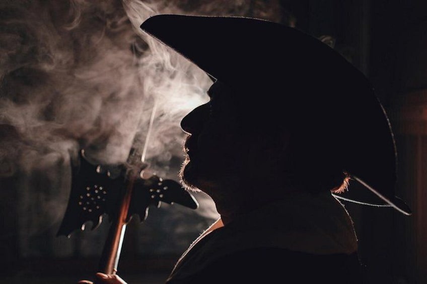 Eine Person mit Cowboyhut spielt Gitarre. 5