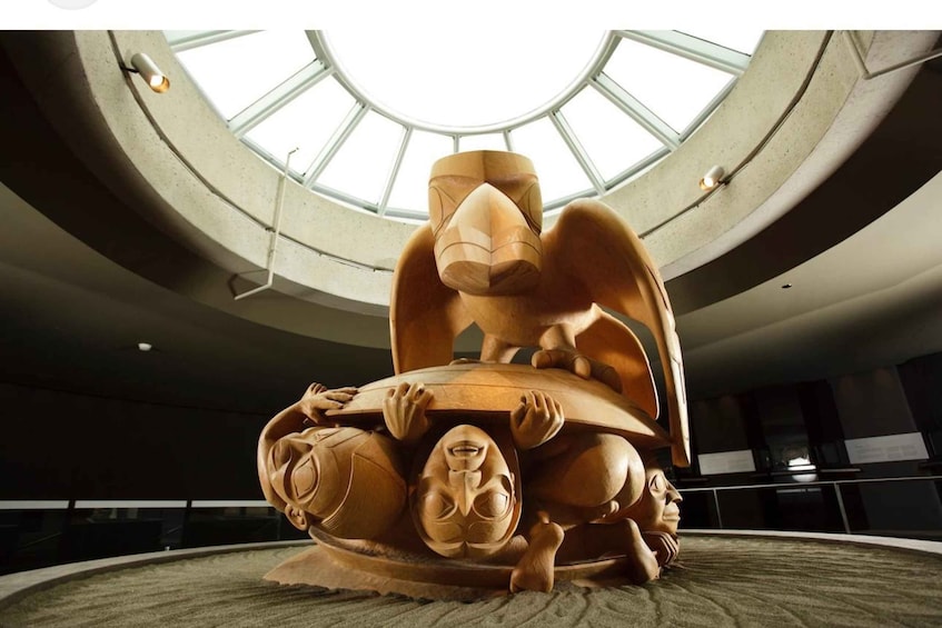 A large wooden sculpture in a circular room with skylights. 3