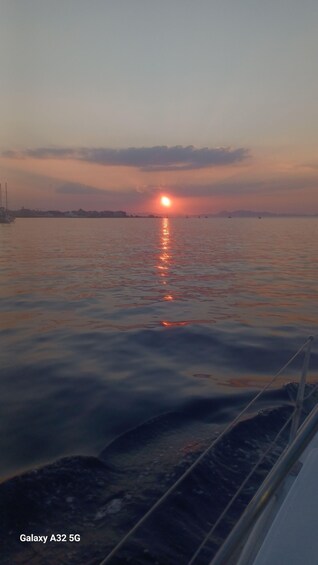 A sunset over a calm body of water with a boat in the foreground. 2