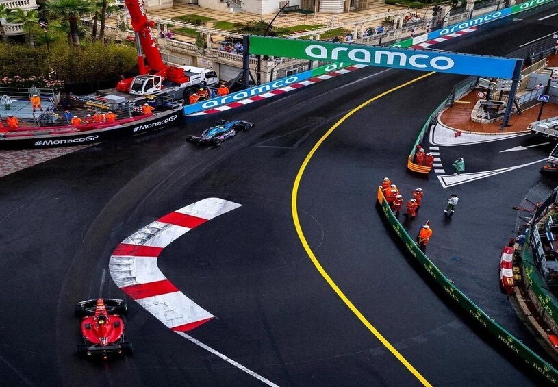 Formula 1 -rata, jossa on punainen auto, nosturi ja työntekijöitä. 3