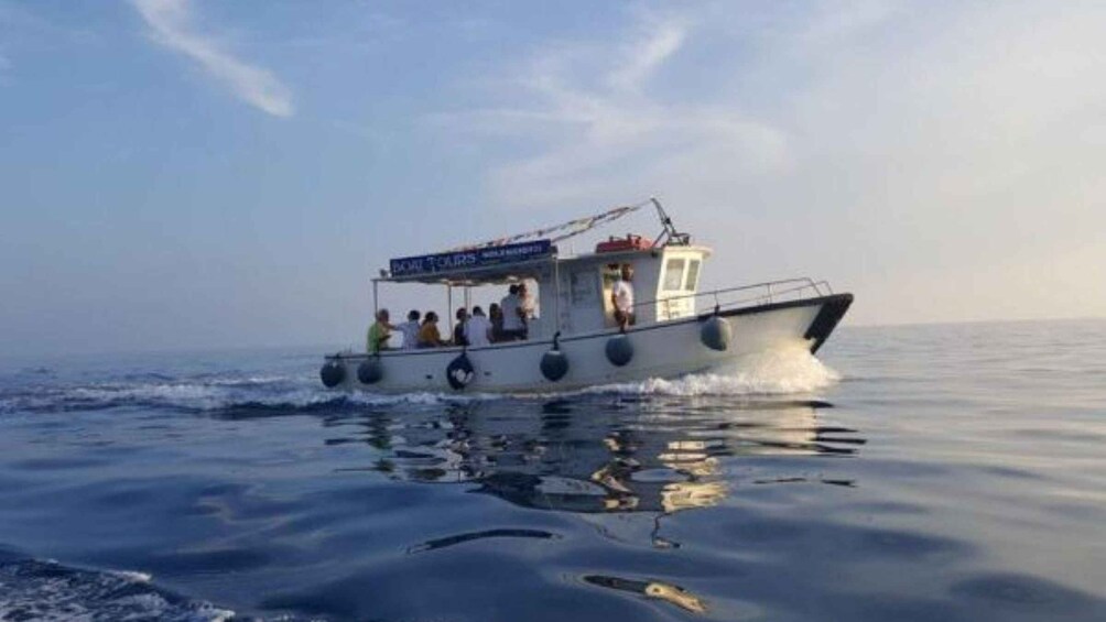 A boat with passengers on a calm sea. 1