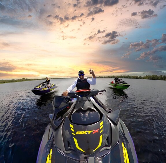 A person riding a jet ski on a body of water with a sunset in the background. 5