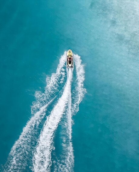 A jet ski creating a wake in turquoise water. 2