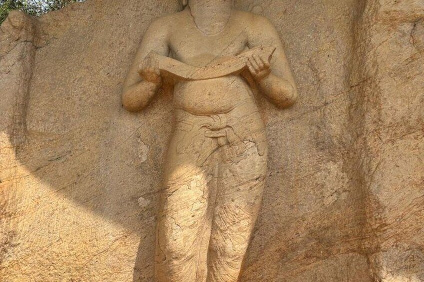 A stone sculpture of a seated figure with a snake. 2