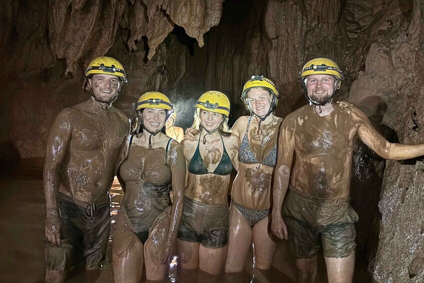 A group of people in a cave with mud-covered bodies and helmets. 2